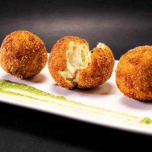 Croquetas rellenas presentadas en tabla de madera