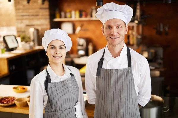 Cocineros con uniforme en cocina profesional